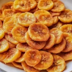 Sweet Cinnamon Air Fryer Banana Chips in a bowl, crispy and golden with a dusting of cinnamon sugar, served as a healthy snack.