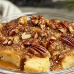 Delicious pecan pie bread pudding served with whipped cream, showcasing the rich texture of custard and crunchy pecans.